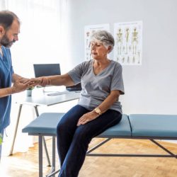 Male doctor chiropractor or osteopath fixing womans wrist with hands movements during visit in manual therapy clinic